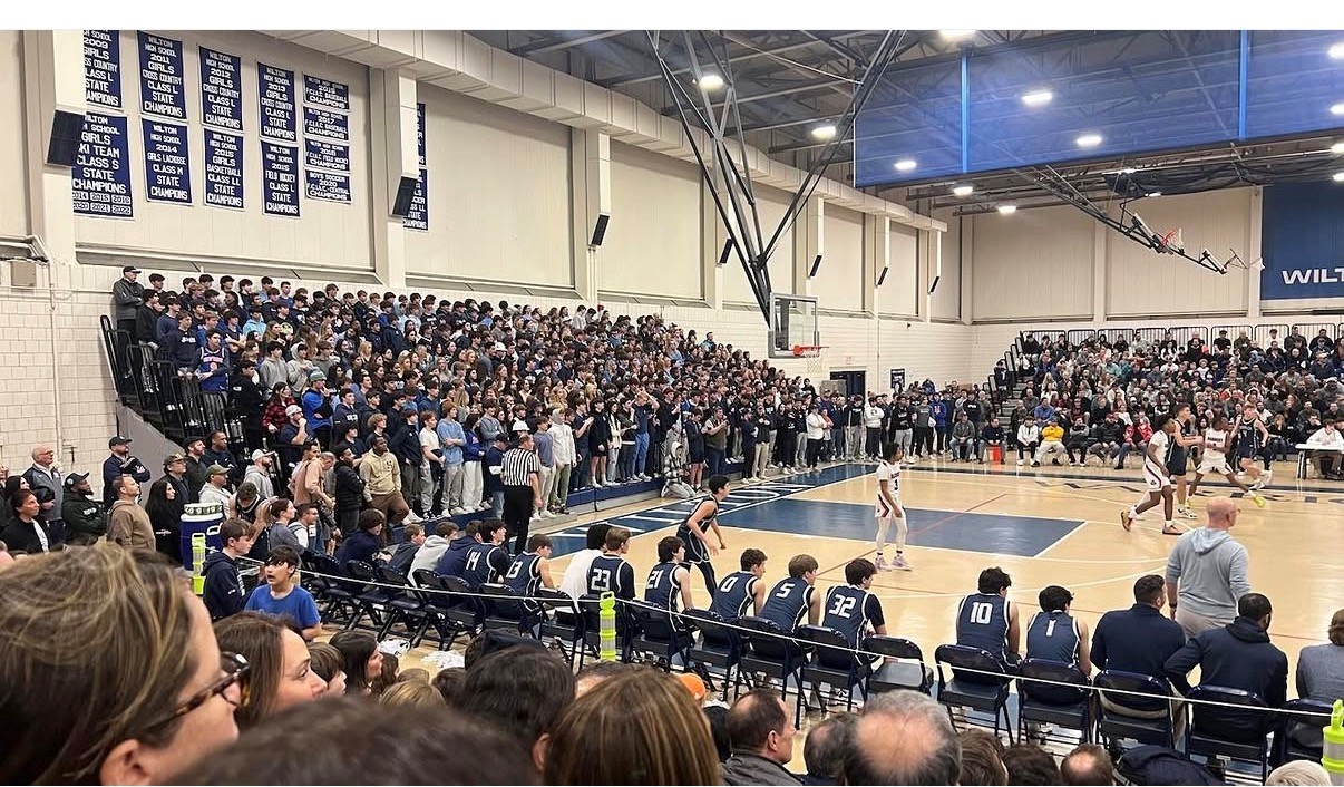 Danbury basketball players and coaches gathered on the court after a game.
