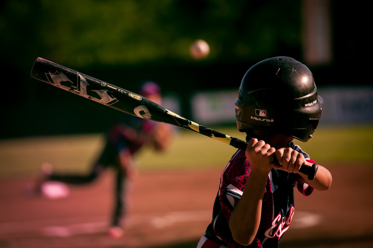 A batter locked in at the plate, players holding each other to the standard.